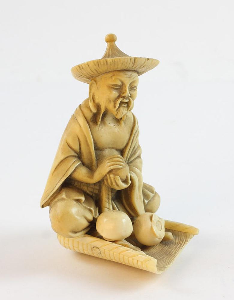 Antique Japanese Carved Bone Sitting Figure: Antique Japanese carved bone sitting figure, 4 1/2" H x 3" W x 3" D.