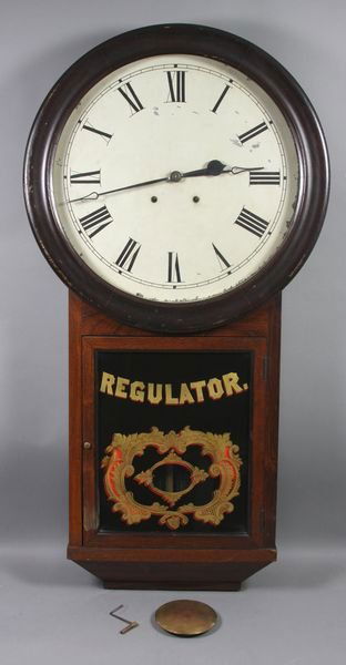 19th C. C. Atkins Large Wall Regulator Clock: 19th Century C. Atkins Clock Company, Bristol, CT, large wall regulator clock, having original 24k gold and painted stenciled door panel, original brass pendulum and key, 39"h. x 21"w. x 4 1/2"d., dia