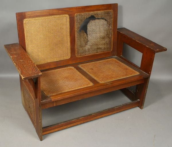 Early 20th C. Limbert Caned Double Settee: Early Limbert (1905-1906) cane-side and cane-back double settee, 36 3/4"h. x 51 1/2"w. x 24 1/2"d., label under arm. Cane back and sides ripped, some scuffing and chips to wood.