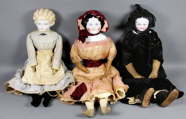 (3) China Head Dolls, Flat Top, Low Brow, etc.: Lot of 3 china head dolls, including: (1) 23" flat top china head, head good with tiny factory dimple on forehead, 1 hair rub on back, old cloth body with tan leather arms, cloth legs, wearing old und