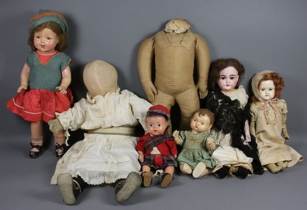 Box of (5) Dolls, 4 Composition and 1 Cloth: Box of (5) dolls, (4) composition dolls cracked or repainted, one bisque head, shoulder plate replaced, one cloth doll with no features (Amish Type) in good condition, all have old appropriate clothin