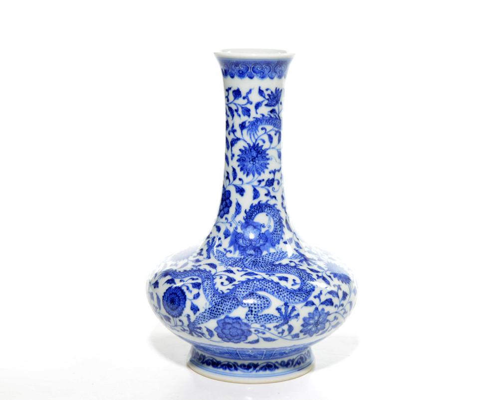 A Chinese Blue and White Dragon Vase: Compress body raising from a flaring foot to a waited long neck and painted with ferocious dragons amidst flower scrolls. Qianlong mark on base. 8 1/4" H.