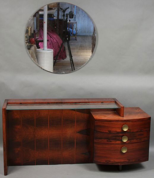 Gilbert Rohde Mahogany Vanity, Herman Miller: Gilbert Rohde (American, 1894-1944), mahogany vanity for the "Herman Miller Furniture Co.", 26 1/4"h. x 55 1/2"w. x 18"d., with circular wall mirror 30"dia. Good condition.