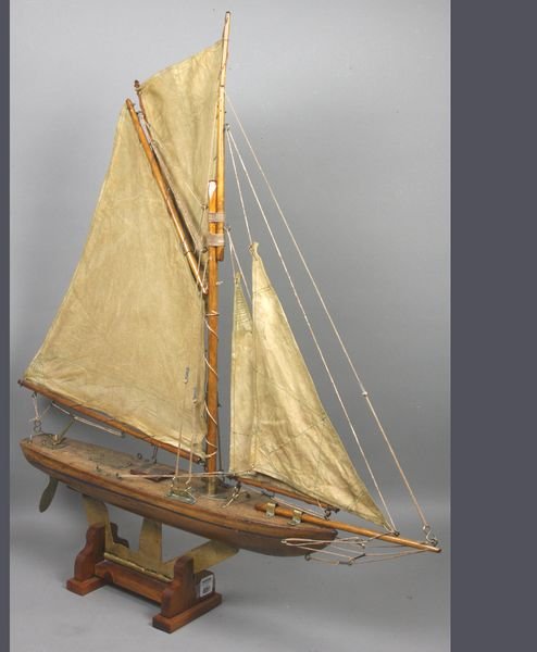 Vintage Pond Yacht with Skeleton Keel: Vintage pond yacht with skeleton keel. Suited with a suit of four stitched sails. Varnished hull, many brass fittings. 28" long x 4" wide x 31" high. Weathered condition.