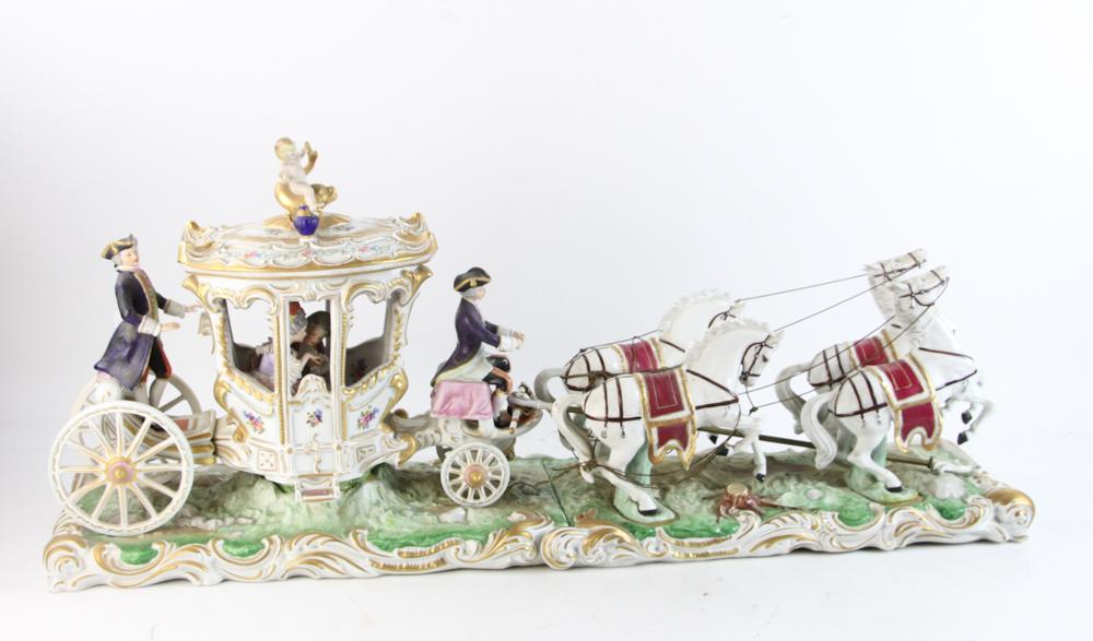 German Porcelain Horse Drawn Carriage: 20th century German porcelain horse-drawn coach with courting couple, driver, footman and young boy on dolphin on top of the carriage, marked 'Crown N Dresden', 14 1/2" H x 33 1/2" L overall x 8" D. N