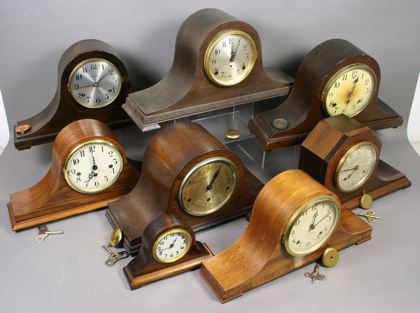 (8) Early 20th C. Hump-back Mantel Clocks: Group of eight (8) early 20th Century hump-back mantel clocks, including (2) Seth Thomas, (1) Howard Miller, (1) New Haven, (1) Waterbury, (1) Sessions, and (2) unmarked. Largest 10 1/2"h. x 17"w. x 5