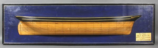 Carved Wooden Half Hull of the "Sea Witch": Carved wooden half hull showing the America's clipper ship "Sea Witch" of 1846. Hull is mounted to a blue backboard and details captain and builder information. Hull is varnished below the waterline w