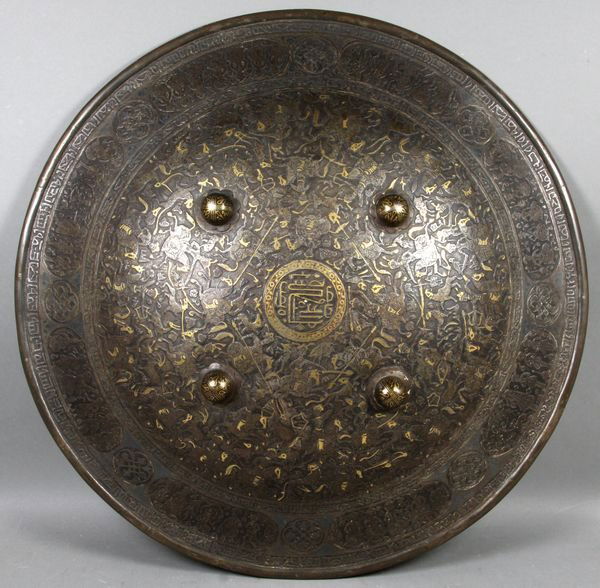 Rare 17th C. Persian Islamic Inlaid Iron Shield: Rare 17th Century Persian Islamic embossed iron shield with gold inlay and Kufic script, 20 1/4"dia. Provenance: Royal Family Collection from Tehran, Iran.