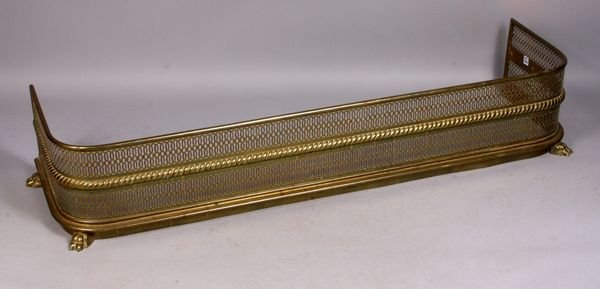 19th C. pierced brass fire fender: 19th Century pierced brass fire fender with paw feet, 11" x 57 1/2" x 17".