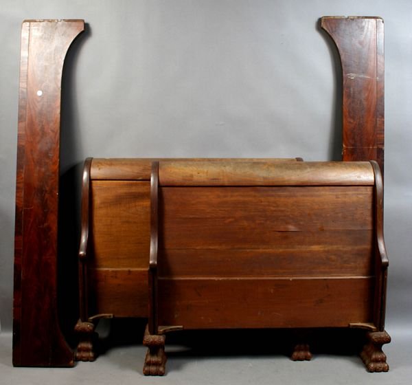 19th C. Mahogany Sleigh Bed with Paw Feet: 19th Century mahogany sleigh bed with carved paw feet, 42 1/4"h. x 47"w. x 91"l. Some splitting to veneer; one small area of veneer loss to each of headboard and footboard.