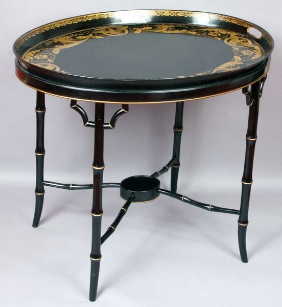 Black and gold painted tole tray table: Black and gold painted tole tray table having eagle design, 25" h. x 30" w. x 23" d., 26 1/2" h. (with tray on top).