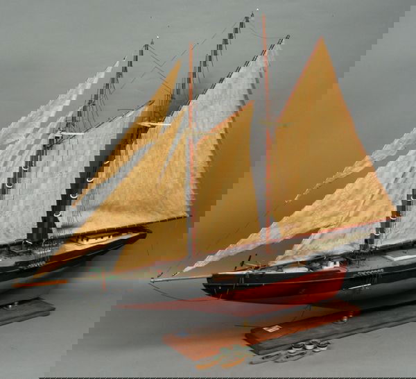 C. 1940 Wooden Model of a Gloucester Schooner: Circa 1940 wooden model of a Gloucester-type schooner, painted black above waterline and red below, 27"h. (includine base) x 35"l. Small piece broken off main boom at mast (but present); a couple of p