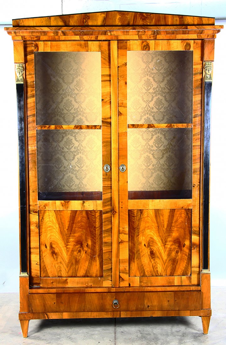 Biedermeier-style Two Door Cabinet: Biedermeier-style two door cabinet with glass front doors, ebonized with gilt columns. Provenance: Hamilton, Massachusetts.