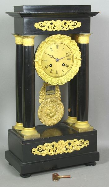 Mid 19th C. French Empire Gilt Bronze and Ebonize: Mid 19th Century French Empire gilt bronze and ebonized wood clock having original pendulum and key, 18"h. x 9 3/8"w. x 5 1/4"d. Good condition.