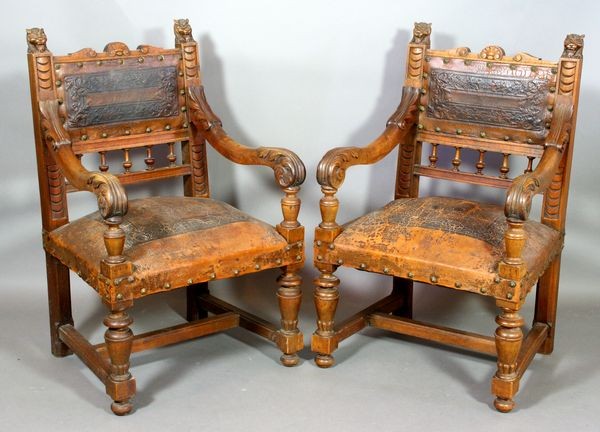 Pr. of Late 19th C. Continental Heavily Carved Ar: Pair of late 19th Century Continental heavily carved armchairs having lion's head finials, tooled leather seat and back, and having fancy rosette nails, 35 3/4"h. x 22 1/2"w. x 19 1/2"d., height of se