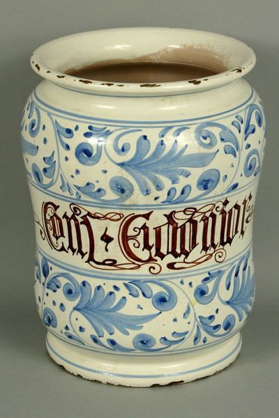 Italian Ceramic Albarello Jar: Italian ceramic albarello jar, blue scroll design, white ground with inscription, 10"h x 6 1/2"dia. Age chips on rim and base, minor abrasions.