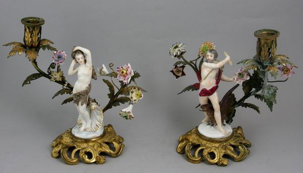 19th C. Candlesticks with Meissen Style Porcelain: 19th Century candlesticks with Meissen style porcelain figures and flowers, on metal stands, 7 3/4"h. One (1) has a missing flower, the other has four (4) missing flowers. No other damage.