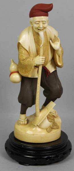 Japanese Carved Ivory Figure: Japanese carved ivory figure with red hat, signed on base, 9 3/4"h (including base) 8 1/2"h (without base) x 4"w x 3"d.