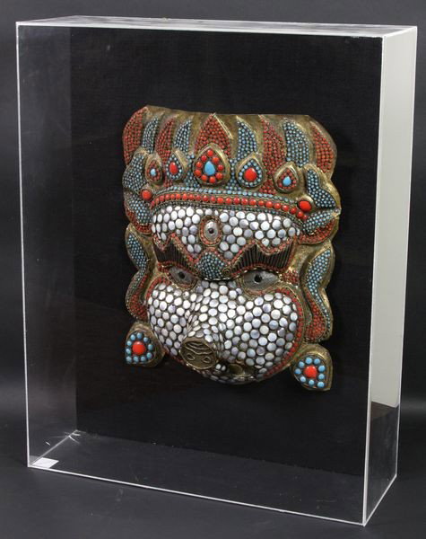 Anthropomorphic Mask,: Anthropomorphic Mask, Thailand, 19th century, human head with boar or elephant features, inlaid with silver, turquoise, and coral, framed in a plexiglass box, 21 3/4" high x 17" wide x 6" deep.