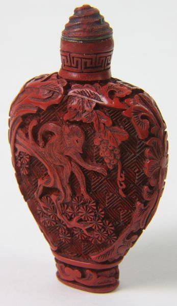 Cinnabar Snuff Bottle: Cinnabar Snuff Bottle, China, 19th century, pear form, carved playing monkey on both sides and floral motif on shoulders, 3" high.
