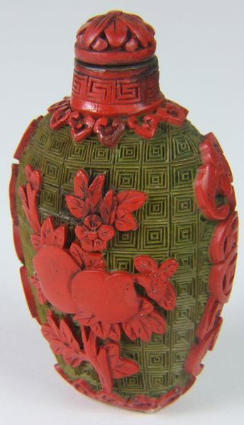 Cinnabar Snuff Bottle: Cinnabar Snuff Bottle, China, 19th century, of pear form, cinnabar over a copper body, carved peach tree on body and bats on each shoulder, 3 1/4" high.