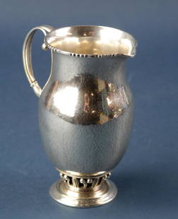 Georg Jensen Hammered Sterling Pitcher: Georg Jensen hammered sterling pitcher no. 180, circa 1933-1934 date mark, 5 3/4" H. Approximately 10.5 troy oz. Good condition. Provenance: Furnishings from the Park Avenue home of a New York