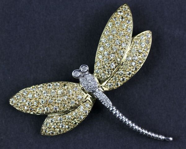 Gold Dragonfly Pin: Yellow and white gold dragonfly pin with twelve (12) diamonds on body and one hundred and one (101) diamond cut brilliant yellow sapphires on wings, 1 3/4"l x 1 7/8"w, 0.4 oz/8 dwt t.w. Undamaged.