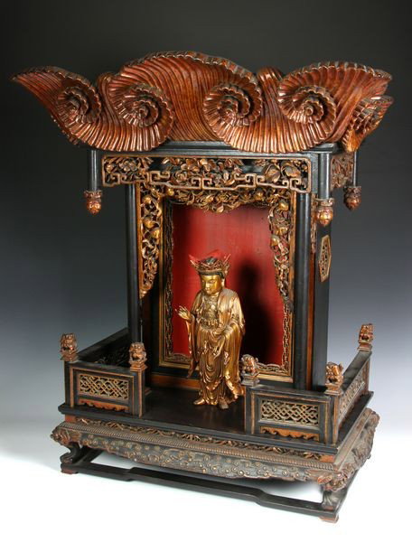Chinese 19th C. Buddhist Shrine: Buddhist Shrine, China, 19th century, wood, the gilt figure of a standing Buddha in elaborately carved, gilt, and painted shrine with foo dog finials and floral and peach borders, 28 1/2" high x 23 1/