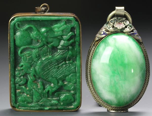 Two Chinese 19th C. Jadeite Pendants: Two Jadeite Pendants, China, 19th century, the oval form mounted on silver, 2 1/4" long, the carved rectangular form mounted in a metal frame, 2 1/8" high x 1 1/2" wide.