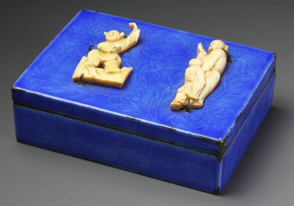Chinese 19th C. Enameled Box: Enameled Box, China, 19th century, blue enamel with dense floral pattern over copper, the hinged lid with two ivory figures held in place with metal prongs, 1 1/4" high x 3 3/4" wide x 2 3/4" deep. * 