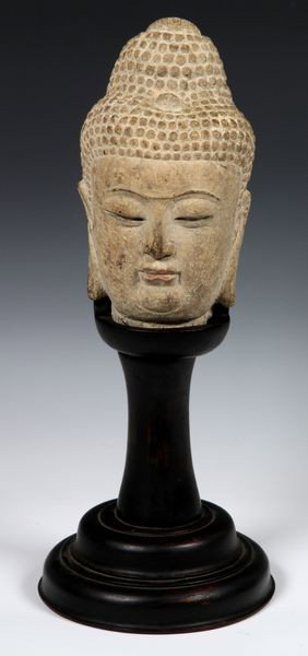 Chinese 19th C. Head of the Buddha: Head of the Buddha, China, 19th century, carved of stone, on a custom wood pedestal, 9" high (head), 17 1/2" high (overall). From the collection of Henry Francis Thompson. Henry Thompson, an importer 