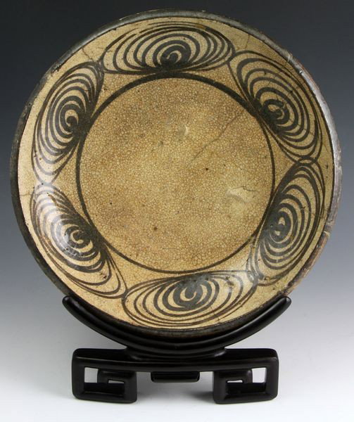 Japanese 18th C. Plate: Ceramic Plate, Japan, 18th century, decorated with horses' eye pattern along the rim, glazed in earthen tones, with carved wood stand, 10 1/4" diameter, old repairs and a few firing flaws. Originally 