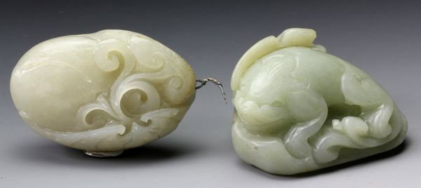 Two Chinese Jade Ornaments: Two Jade Ornaments, China, one in an ovoid shape carved with a foliate form, the other of a mythical creature, 2" high x 1 3/4" wide and 2" high x 1 1/4" wide.
