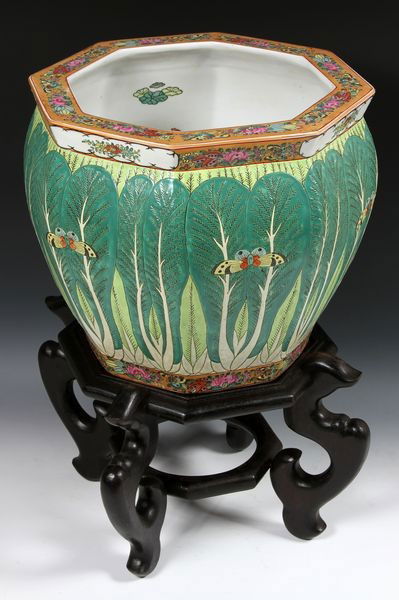 Chinese 20th C. Porcelain Fish Bowl: Porcelain Fish Bowl, China, early 20th century, the octagonal form painted with cabbage leaves and butterflies around the body, floral design along the rim and base, on octagonal wood stand with four