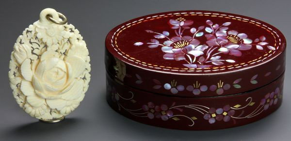 Chinese 20th C. Ivory Pendant: Ivory Pendant, China, 20th century, the coral form intricately carved with a lotus flower, in its original box with mother-of-pearl inlaid floral designs, pendant is 2" long.