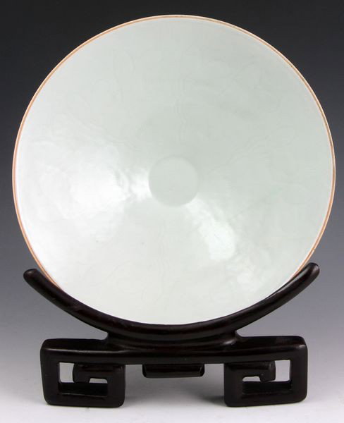 Chinese Song Dynasty Bowl: Porcelain Bowl, China, Song Dynasty (960 - 1279), in the form of a hat, incised with a floral design, on wood stand, 2 1/4" high x 8" diameter, old restoration. Originally acquired by C.T. Loo & Co. o