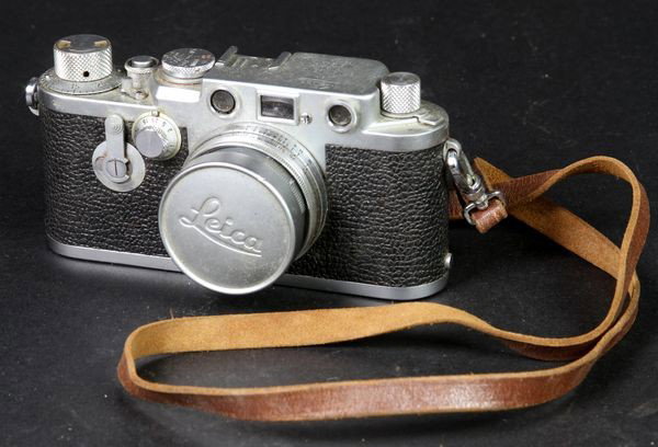 Leica 35mm Camera: Leica Nr. 824964 35mm camera with Leitz Wetzlar Summicron f=5cm 1:2 lens, with leather case. Owner's number scratched in top/back, operational condition unknown.