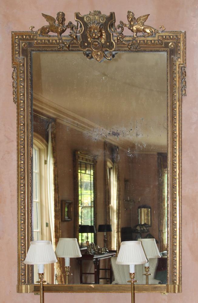 19th Century English Gilded Pier Mirror, Lion and Griffins: 19th century English gilded pier mirror with figural lion's head and griffin-decorated crest, 66 1/2" H x 41" W. Some silver loss, damage to tail of one griffin, otherwise good condition. Provenance: 