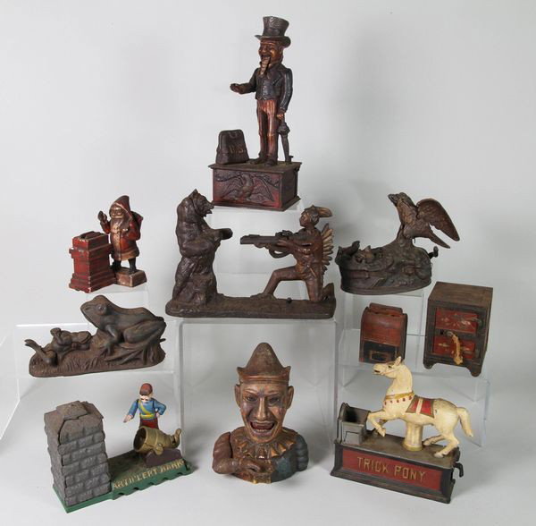 Lot of 10 Cast Iron Banks: Collection of 10 cast iron mechanical banks to include "Trick Pony", Indian and bear, mailbox, "Humpty, Dumpty", bird and nest, safe, frog, Santa Claus, "Artillery", "Uncle Sam", tallest 11"h. Found i