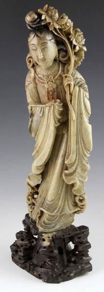 Chinese 19th C. Soapstone Figure: Figure of a lady, China, late 19th century, standing with the left hand holding a bouquet of lotus flowers, embellished with black and red paint, soapstone, 15 3/4"h.