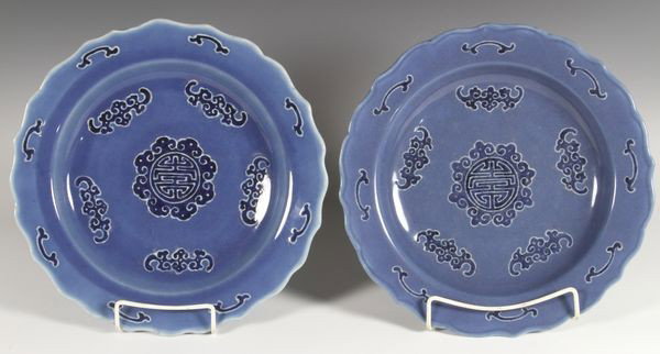 Pair of Chinese 18th/19th C. Plates: Pair of blue glazed plates, China, 18th to 19th century, decorated with the Chinese character for longevity at the center, surrounded by bats, with ruyi motifs along the scalloped rim, Qianlong mark o