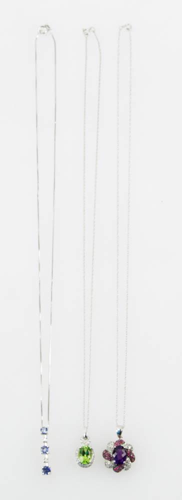 Group of 14k Gold Pendants with Gemstones: Three pendants, to include: 14k white gold, diamond, and tanzanite, on 17 3/4" 14k chain; 14k white gold, diamond, ruby, and amethyst, on 17 3/4" 14k chain; 14k white gold, diamond, and peridot, on 18