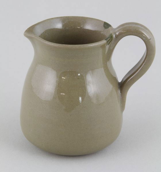 Marblehead Pottery Creamer: Marblehead pottery creamer, 3 3/4"h x 4"w. Minor chip on stand.
