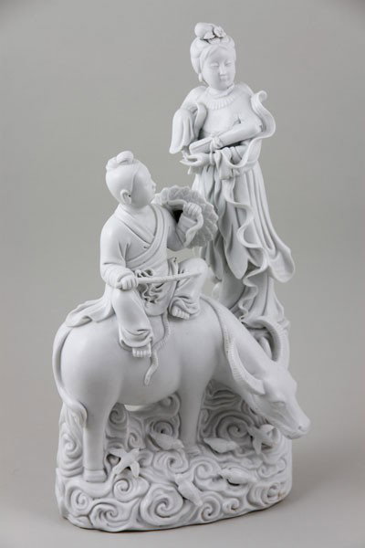 Chinese Blanc de Chine: Chinese blanc de chine figurine group featuring a boy on an ox and a standing girl with birds, 15" x 7 1/2".