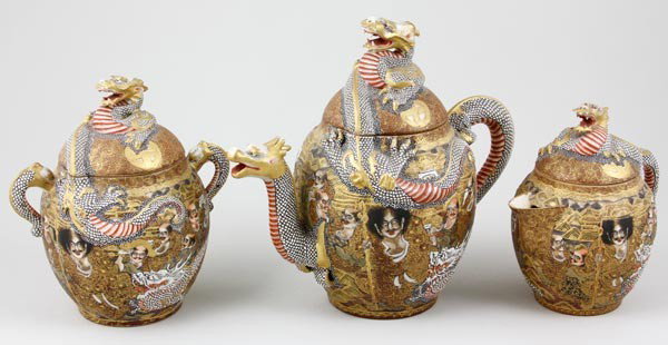 19th C. Japanese Tea Set: 19th century Japanese tea set having dragon and face design, signed on base, 7 1/2" x 8 1/2" (teapot), 7" x 6" (sugar), 5 1/2" x 6" (creamer).