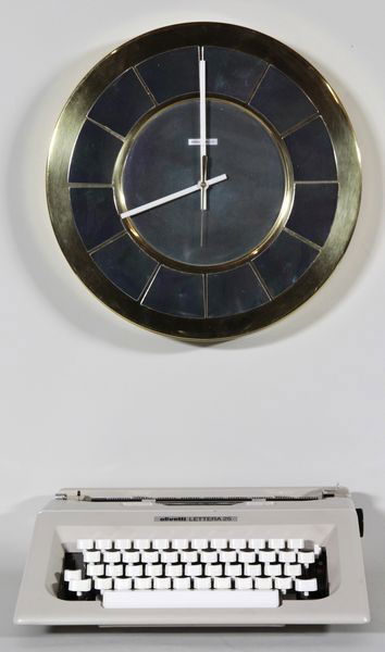Letter Typewriter and Miller Clock: Lot of two items to include: Olivetti Letter manual typewriter, circa 1960's, 3 3/4"h x 14"w x 12"d; Howard Miller clock, brass and chrome, circa 1970's, 14 1/2"dia. x 2"d.
