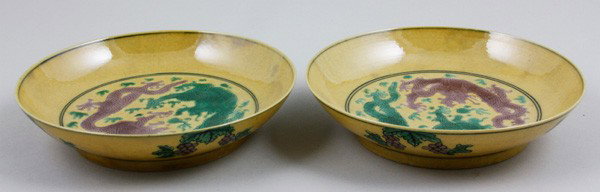 Chinese Early 20th C. Pair of Porcelain Dishes: Pair of Yellow Glazed Dishes, China, early 20th century, the interior each painted with a pair of dragons within double ring, the exterior with auspicious fruits, mark on base within double ring, 1 1/