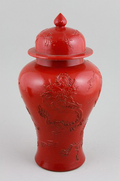 Chinese Early 20th C. Porcelain Vase: Red Glazed Vase, China, early 20th century, the baluster form decorated with dragons chasing pearls amongst clouds, the cover with auspicious emblems including pair of scrolls, Qianlong mark on base, 
