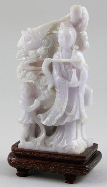 Chinese Early 20th C. Jadeite Guan Yin: Jadeite Guan Yin, China, early 20th century, carved in relief with attendant, holding a vase on one hand and horsetail duster on the other, with a bird soaring amongst clouds in the background, on woo