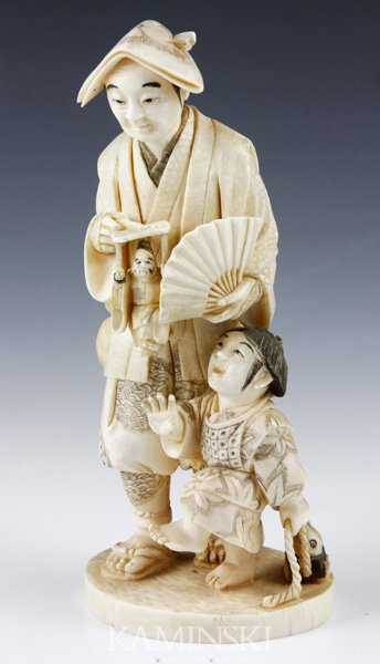 19th C. Japanese Ivory Figure: Carved figure, Japan, 19th century, ivory, of a man carrying a puppet, a child next to him, mark on base, 6 1/4"
